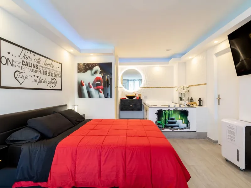 Vue d'ensemble lumineuse de la suite LoveRoom66 : lit king size et balnéo